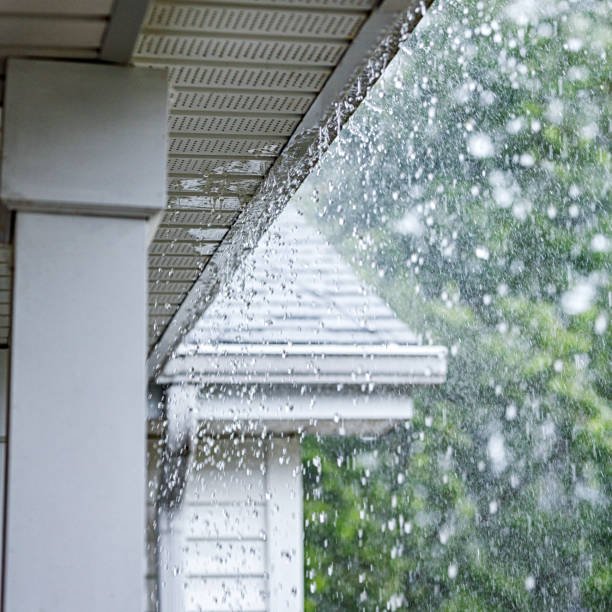 Heavy rain splashing off roof shingles and damaged gutters causing roof leaks.