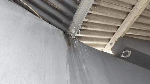 Water traveling along roof framing and metal structural beams before leaking onto interior ceiling.
