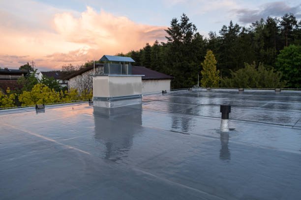 Standing water on a flat New Jersey roof after a rainstorm, leading to unseen moisture absorption in the decking below.